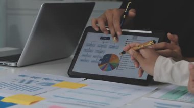 İşletme ekibi, ofiste dizüstü bilgisayarla finansal çizelgeleri tartışıyor..