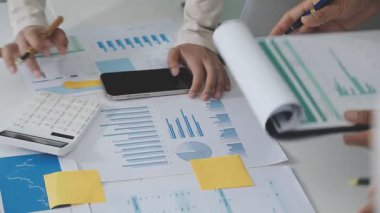 Yakın plan - İş kadınlarının elleri işyerindeki grafiklere ve çizelgelere işaret ediyor