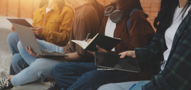 Üniversite kampüsünde birlikte yürüyen mutlu öğrenciler, derslerden sonra dışarıda sohbet edip gülüyorlar.