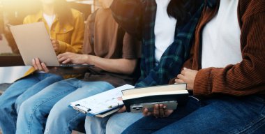 Üniversite kampüsünde birlikte yürüyen mutlu öğrenciler, derslerden sonra dışarıda sohbet edip gülüyorlar.