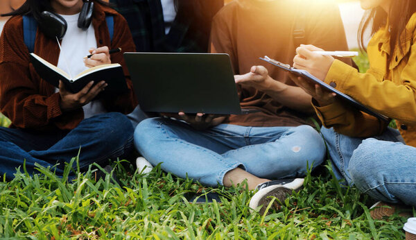 Счастливые студенты, гуляющие вместе по университетскому кампусу, общающиеся и смеющиеся на открытом воздухе после занятий