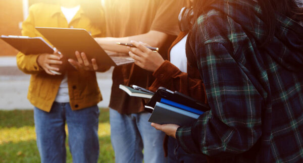 Счастливые студенты, гуляющие вместе по университетскому кампусу, общающиеся и смеющиеся на открытом воздухе после занятий