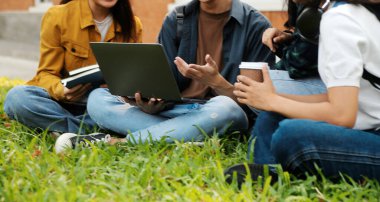 Üniversite kampüsünde birlikte yürüyen mutlu öğrenciler, derslerden sonra dışarıda sohbet edip gülüyorlar.