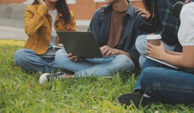 Üniversite kampüsünde birlikte yürüyen mutlu öğrenciler, derslerden sonra dışarıda sohbet edip gülüyorlar.