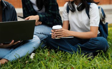 Üniversite kampüsünde birlikte yürüyen mutlu öğrenciler, derslerden sonra dışarıda sohbet edip gülüyorlar.