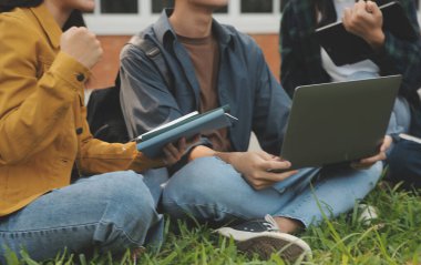 Üniversite kampüsünde birlikte yürüyen mutlu öğrenciler, derslerden sonra dışarıda sohbet edip gülüyorlar.