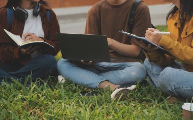 Üniversite kampüsünde birlikte yürüyen mutlu öğrenciler, derslerden sonra dışarıda sohbet edip gülüyorlar.