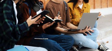 Üniversite kampüsünde birlikte yürüyen mutlu öğrenciler, derslerden sonra dışarıda sohbet edip gülüyorlar.