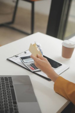 Evde kredi kartı tutan ve akıllı telefonlar kullanan kadınlar. Çevrimiçi alışveriş, internet bankacılığı, çevrimiçi mağaza, ödeme, harcama parası, e-ticaret ödemesi, kredi kartı, konsept