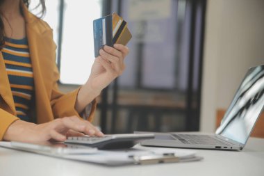 Evde kredi kartı tutan ve akıllı telefonlar kullanan kadınlar. Çevrimiçi alışveriş, internet bankacılığı, çevrimiçi mağaza, ödeme, harcama parası, e-ticaret ödemesi, kredi kartı, konsept