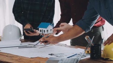 Mühendis plan ve mimar üzerinde çalışıyor.