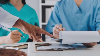 Bir grup doktor klinikte tıbbi muayeneyi tartışıyor ve tartışıyorlar..