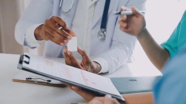 Doktor ve hemşire tıp bürosundaki panoya yazı yazıyorlar.