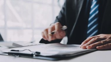 Takım elbiseli ve kravatlı işadamı ofiste çalışıyor.