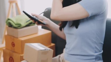 Asyalı kadın internet üzerinden akıllı telefon ve laptopla alışveriş yapıyor..