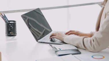 Yakın plan - modern ofisteki klavyede daktilo ve dizüstü bilgisayarda daktilo yazan iş kadını.