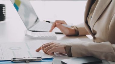 İş kadını dizüstü bilgisayar ve hesap makinesi kullanıyor