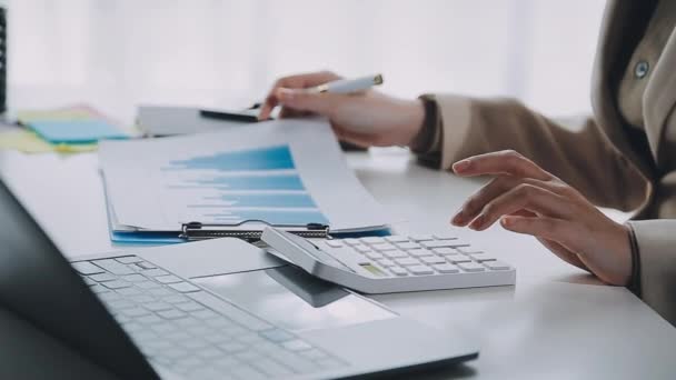 ビジネスマン オフィスの机 会計および計算概念の財務報告が付いているペンおよび計算機を握る手 — ストック動画