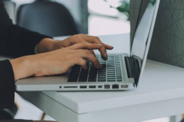 Modern dizüstü bilgisayarla gelir tabloları ve grafiklerini analiz eden iş ekibini kapatın. İş analizi ve strateji kavramı.