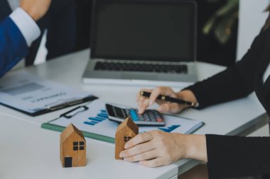 Kadın eli ev modelini tutuyor, küçük minyatür beyaz oyuncak evi. Ev kredisi sigortası hayali eve taşınma ve emlak konsepti