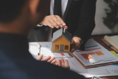 Emlakçı ve müşteri ev, sigorta ya da emlak satın almak için sözleşme imzalarlar. Ev kiralarlar, sigorta yaptırırlar, emlak veya emlak kredisi alırlar..