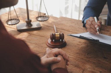 Adalet ve hukuk kavramı. Hukuk Müşaviri tokmak ve yasal hukuk veya yasal ile imzalanmış bir sözleşme istemciye sunar arka planda hukuk firmasında takım toplantısı