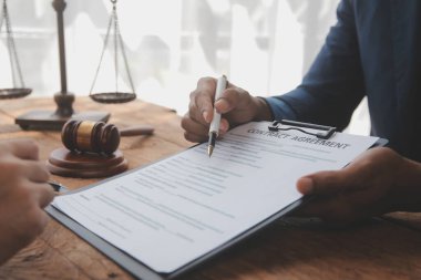 Adalet ve hukuk kavramı. Hukuk Müşaviri tokmak ve yasal hukuk veya yasal ile imzalanmış bir sözleşme istemciye sunar arka planda hukuk firmasında takım toplantısı