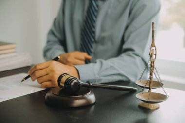 Adalet ve hukuk kavramı. Hukuk Müşaviri tokmak ve yasal hukuk veya yasal ile imzalanmış bir sözleşme istemciye sunar arka planda hukuk firmasında takım toplantısı