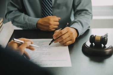Adalet ve hukuk kavramı. Hukuk Müşaviri tokmak ve yasal hukuk veya yasal ile imzalanmış bir sözleşme istemciye sunar arka planda hukuk firmasında takım toplantısı