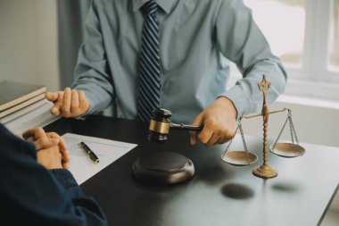 Adalet ve hukuk kavramı. Hukuk Müşaviri tokmak ve yasal hukuk veya yasal ile imzalanmış bir sözleşme istemciye sunar arka planda hukuk firmasında takım toplantısı