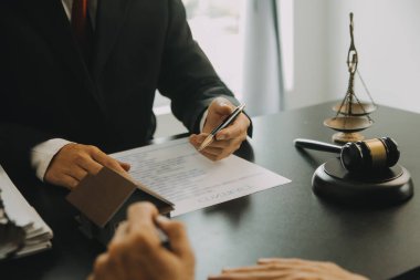 Adalet ve hukuk kavramı. Hukuk Müşaviri tokmak ve yasal hukuk veya yasal ile imzalanmış bir sözleşme istemciye sunar arka planda hukuk firmasında takım toplantısı
