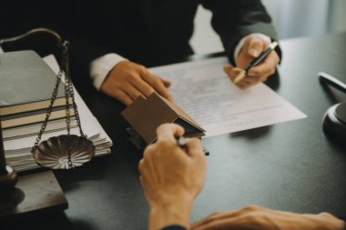 Adalet ve hukuk kavramı. Hukuk Müşaviri tokmak ve yasal hukuk veya yasal ile imzalanmış bir sözleşme istemciye sunar arka planda hukuk firmasında takım toplantısı