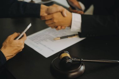 Adalet ve hukuk kavramı. Hukuk Müşaviri tokmak ve yasal hukuk veya yasal ile imzalanmış bir sözleşme istemciye sunar arka planda hukuk firmasında takım toplantısı