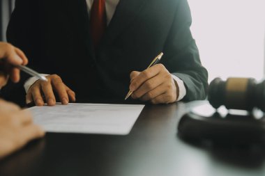 Adalet ve hukuk kavramı. Hukuk Müşaviri tokmak ve yasal hukuk veya yasal ile imzalanmış bir sözleşme istemciye sunar arka planda hukuk firmasında takım toplantısı