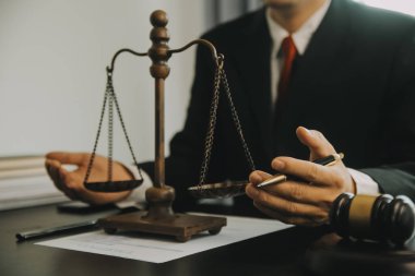 Adalet ve hukuk kavramı. Hukuk Müşaviri tokmak ve yasal hukuk veya yasal ile imzalanmış bir sözleşme istemciye sunar arka planda hukuk firmasında takım toplantısı