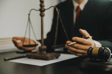Adalet ve hukuk kavramı. Hukuk Müşaviri tokmak ve yasal hukuk veya yasal ile imzalanmış bir sözleşme istemciye sunar arka planda hukuk firmasında takım toplantısı