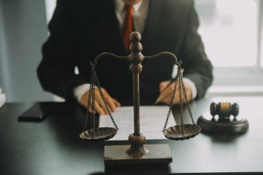 Adalet ve hukuk kavramı. Hukuk Müşaviri tokmak ve yasal hukuk veya yasal ile imzalanmış bir sözleşme istemciye sunar arka planda hukuk firmasında takım toplantısı