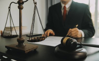 Adalet ve hukuk kavramı. Hukuk Müşaviri tokmak ve yasal hukuk veya yasal ile imzalanmış bir sözleşme istemciye sunar arka planda hukuk firmasında takım toplantısı