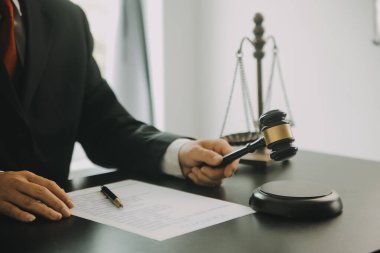 Adalet ve hukuk kavramı. Hukuk Müşaviri tokmak ve yasal hukuk veya yasal ile imzalanmış bir sözleşme istemciye sunar arka planda hukuk firmasında takım toplantısı