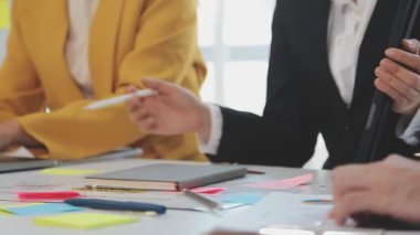 İş adamları masaüstünde finansal planı tartışıyor ve analiz ediyorlar.