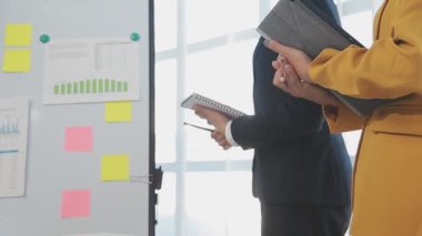 Toplantıda panosu ve grafiği olan iş kadını.