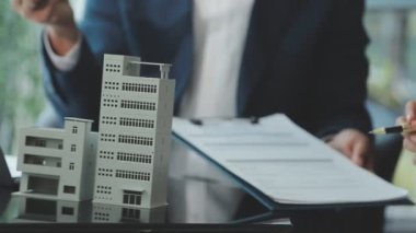 İş adamlarının ellerini ev modeliyle kapatın.