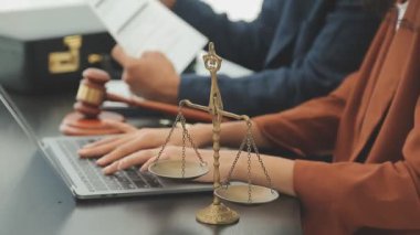 Avukatlar ya da avukatlar dizüstü bilgisayar ve hukuki belgeler ile çalışıyor.