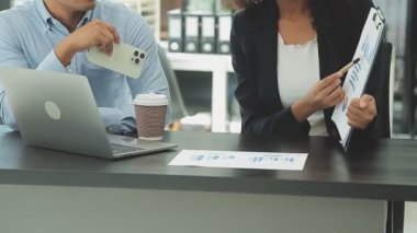 Ofiste belgelerle çalışan genç bir iş adamı.