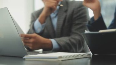 Modern bir ofiste dizüstü bilgisayarla çalışan bir iş ekibi.