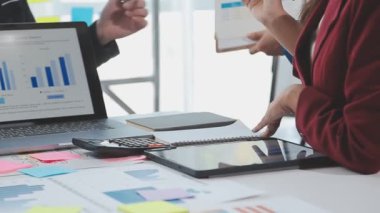Modern ofiste dizüstü bilgisayar ve finansal verilerle iş ekibi toplantısı