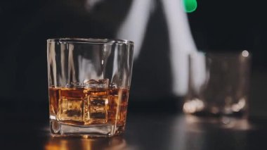 Bir barın arka planında bir bardak viski.