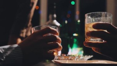 Elinde viski ve buz bardakları tutan adam.
