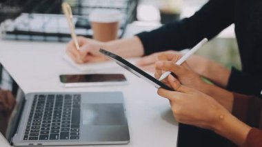 Kafede dizüstü bilgisayarla çalışan genç bir kadın..