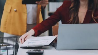 Ofiste dizüstü bilgisayarda çalışan genç bir iş kadını.